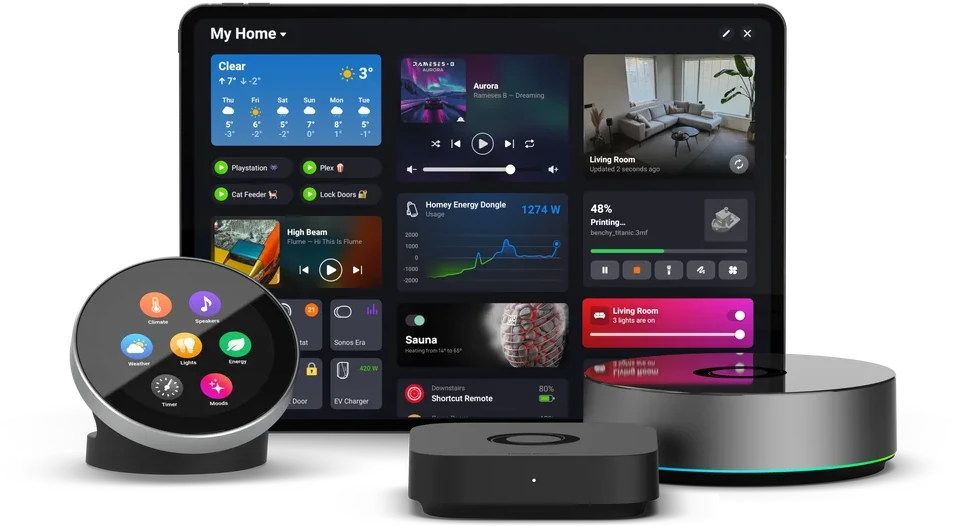 Les boîtiers Homey et une télécommande à écran, devant une tablette qui affiche un Dashboard Homey